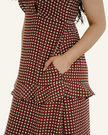 Person wearing a brown polka dot dress