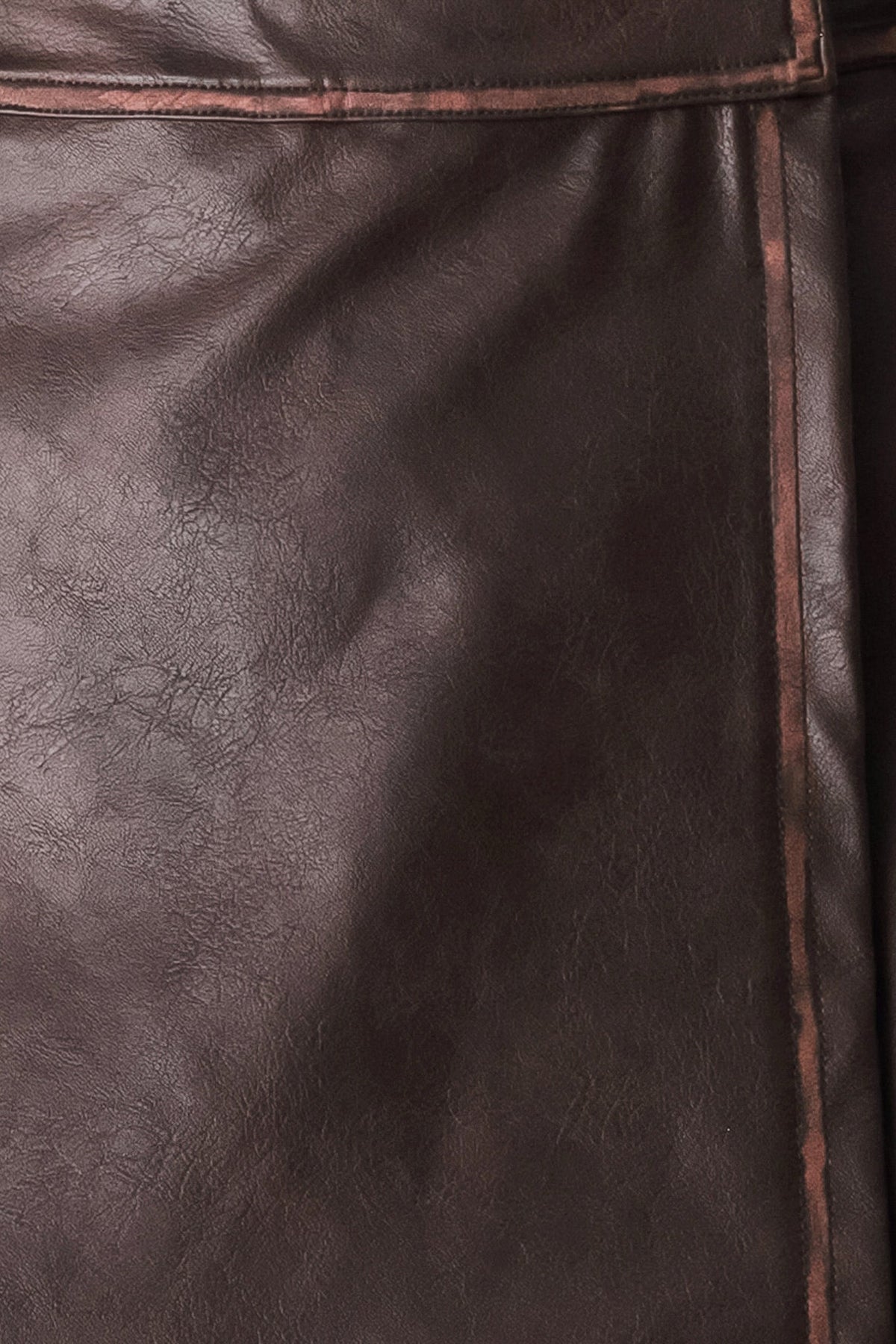 Close-up of dark brown textured leather with visible grain and a thin contrasting stitched seam.