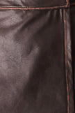 Close-up of dark brown textured leather with visible grain and a thin contrasting stitched seam.