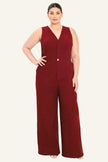 A woman modeling a sleeveless burgundy wide-leg jumpsuit with a V-neckline and front button detail, photographed against a plain light background.