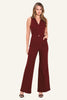 A woman modeling a sleeveless, deep burgundy jumpsuit with a V-neckline, front buttons, and wide-leg pants, set against a plain off-white studio background.